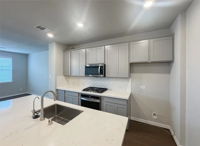 a kitchen with kitchen island a sink stainless steel appliances and cabinets