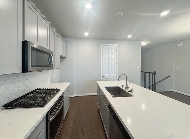 a kitchen that has a sink and a stove top oven