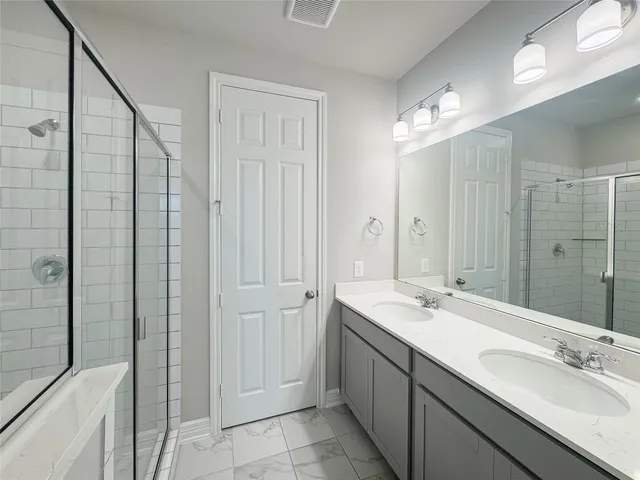 a bathroom with a double vanity sink a mirror and a shower