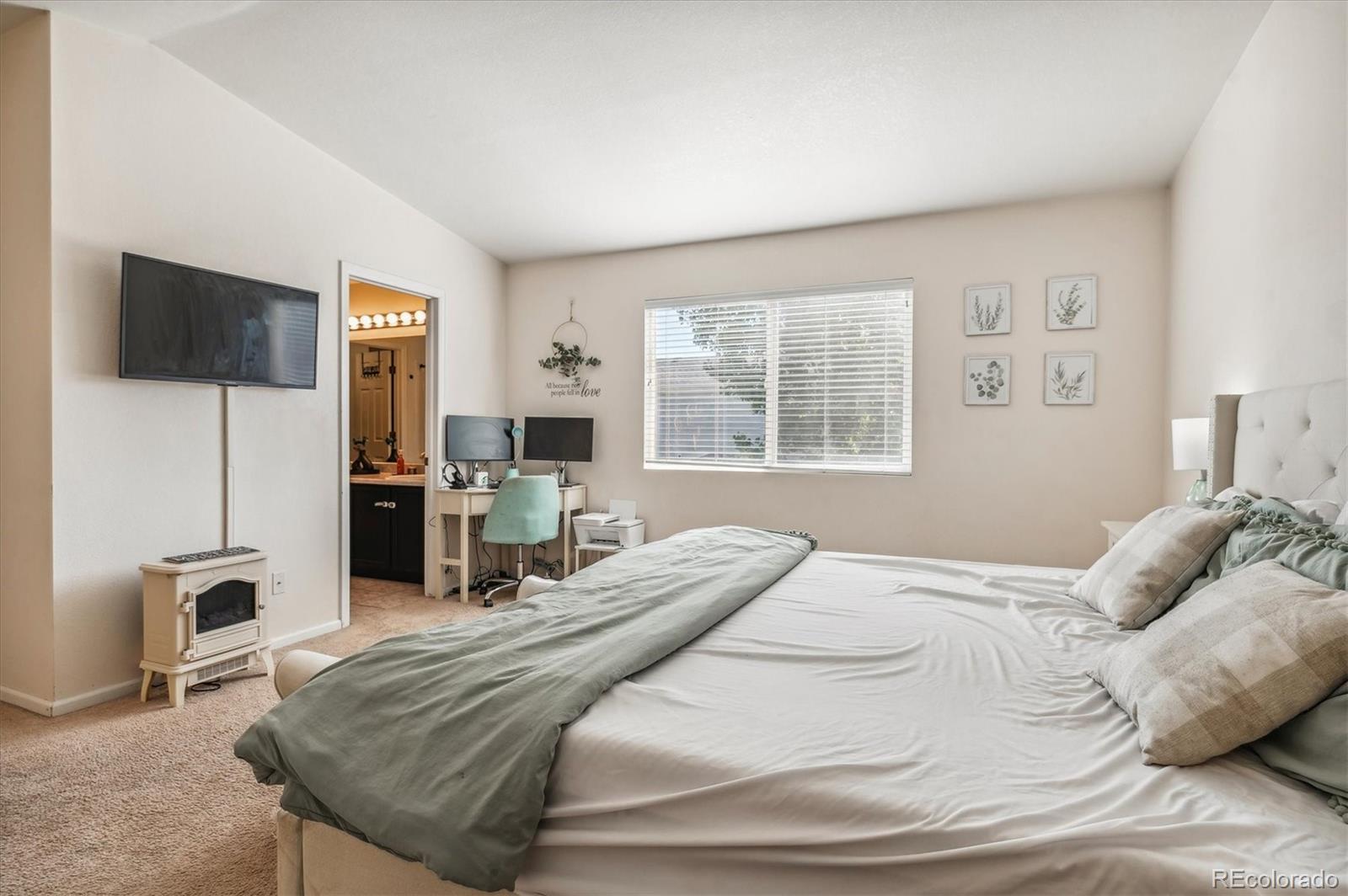 1345 Trail Ridge Road Longmont, CO 80504 - Photo 13 of 25 a bedroom with a bed a chair and a flat screen tv