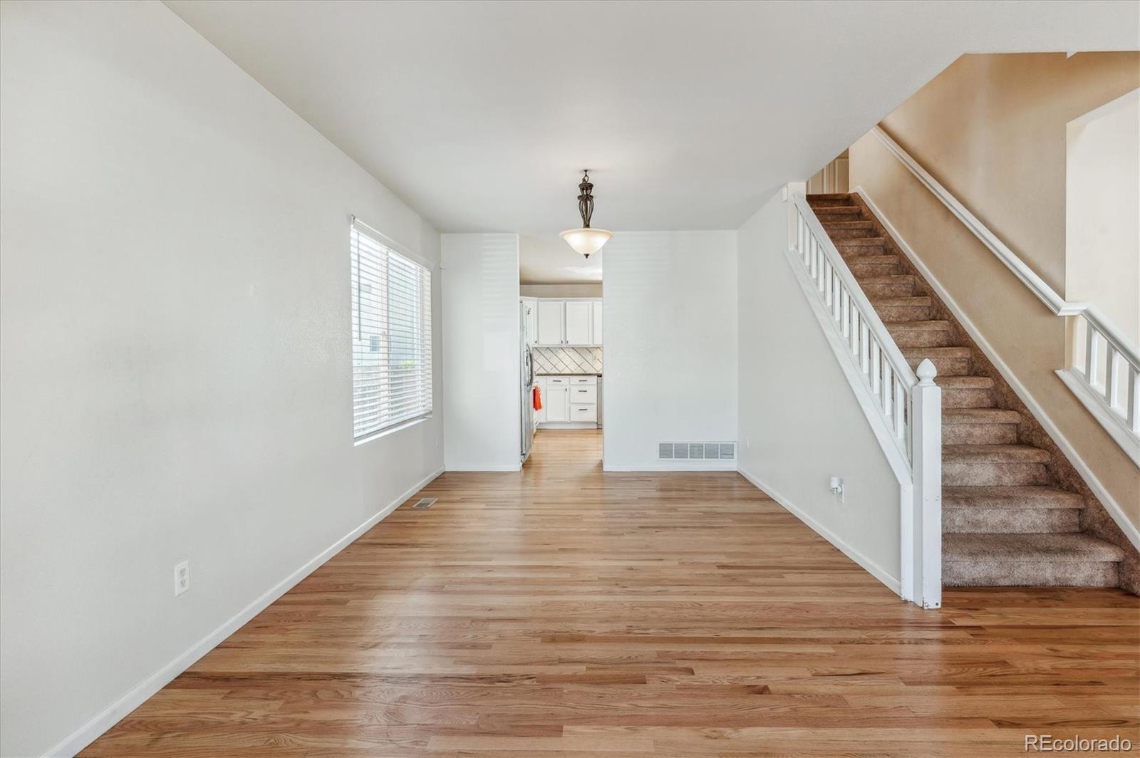 1345 Trail Ridge Road Longmont, CO 80504 - Photo 4 of 25 a view of an empty room with wooden floor and staircase