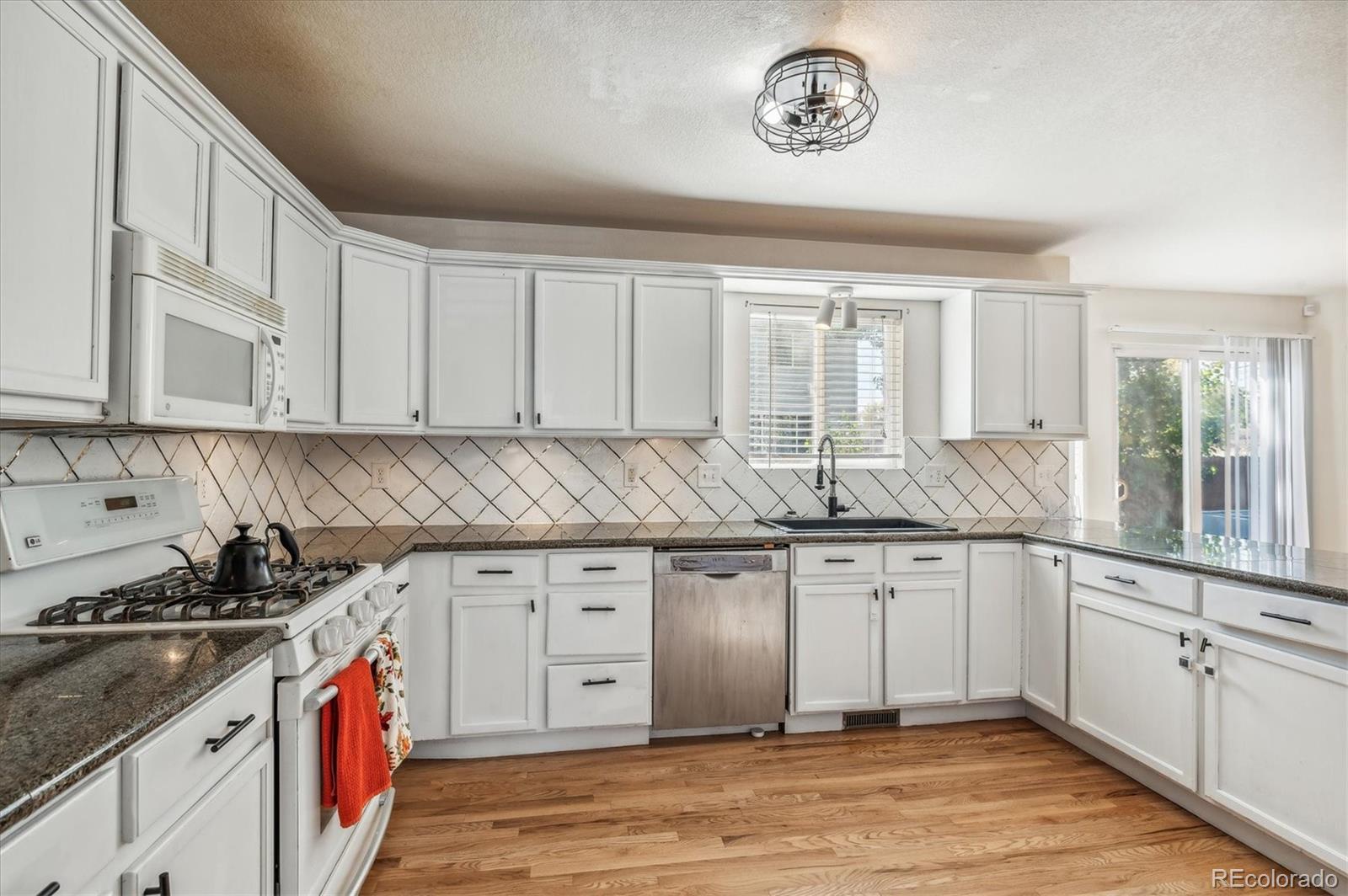 1345 Trail Ridge Road Longmont, CO 80504 - Photo 6 of 25 a kitchen with granite countertop a sink and cabinets