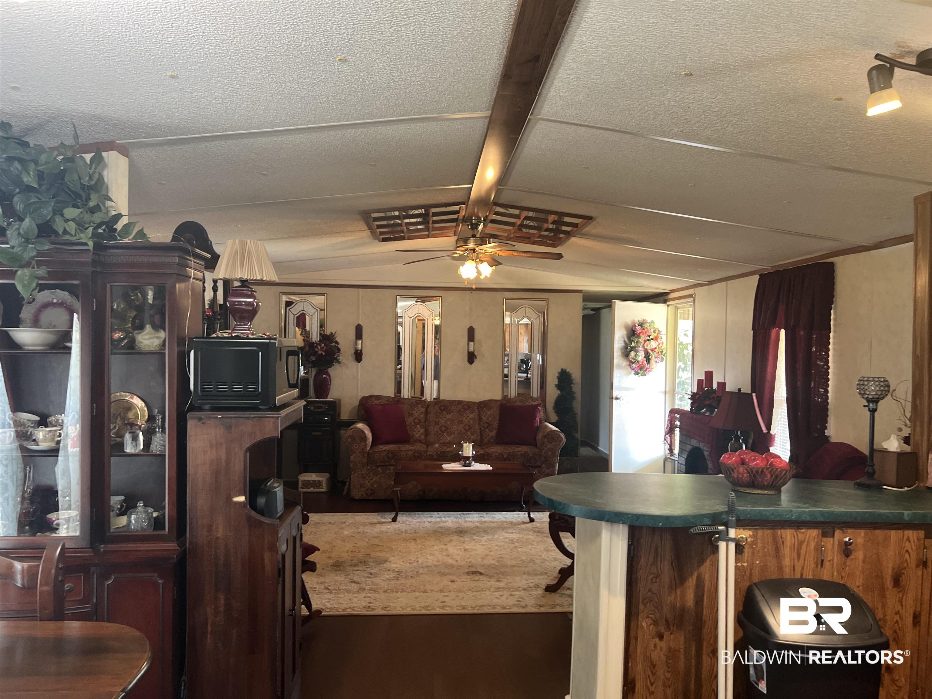 1177 McMillan Road Monroeville, AL 36460 - Photo 14 of 21 Living room with wood finished floors, a ceiling fan, and lofted ceiling