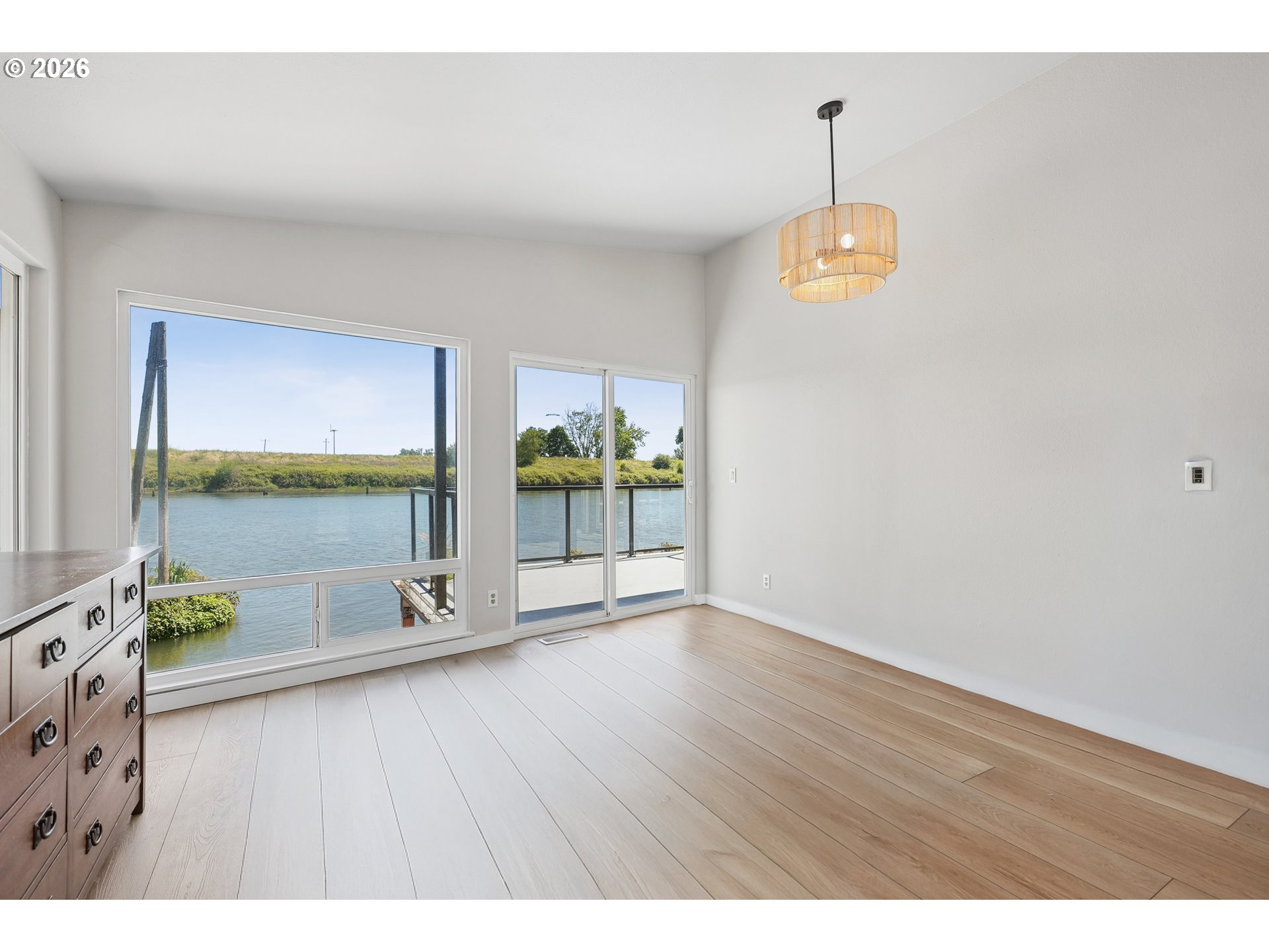 14936 Northwest Mill Road, Unit K Portland, OR 97231 - Photo 22 of 33 a view of an empty room with a window and wooden floor