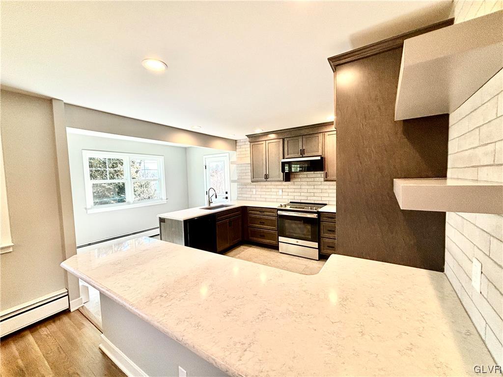 3172 Shakespeare Road Bethlehem, PA 18017 - Photo 8 of 19 a kitchen with stainless steel appliances a stove a sink a microwave a refrigerator white cabinets and wooden floor