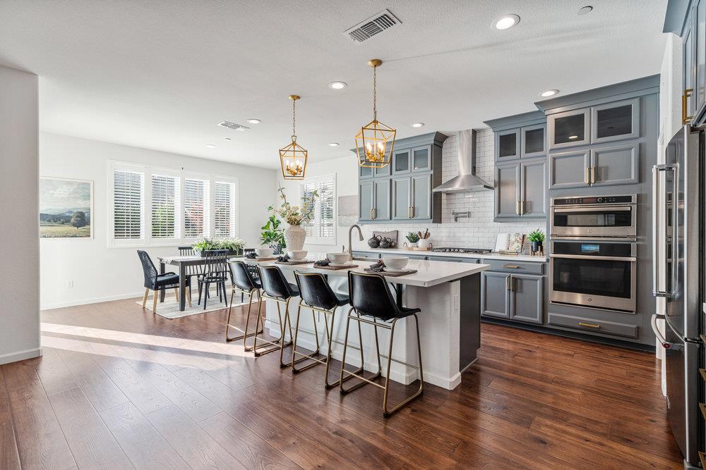 20 Hospital Road Hollister, CA 95023 - Photo 13 of 46 a kitchen with stainless steel appliances kitchen island wooden floors and white cabinets