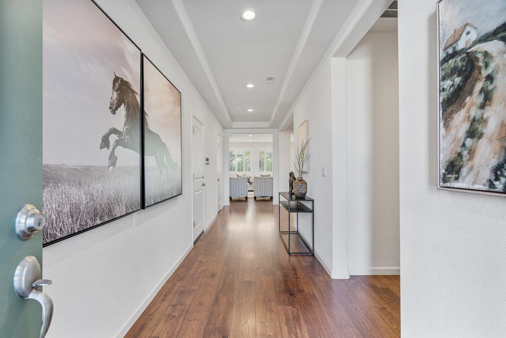 20 Hospital Road Hollister, CA 95023 - Photo 6 of 46 a view of a hallway to a livingroom with wooden floor and furniture