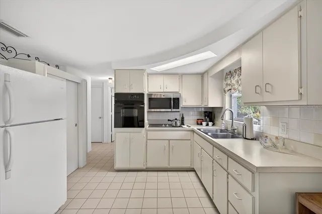 a kitchen with stainless steel appliances a refrigerator sink and cabinets