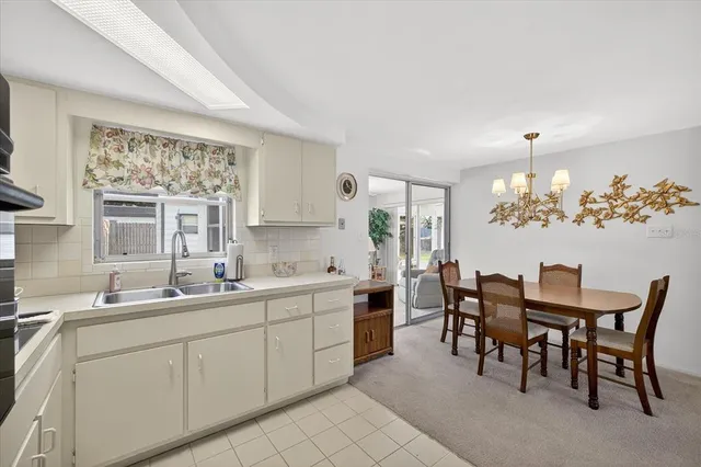 a kitchen with a dining table chairs sink and granite counter tops