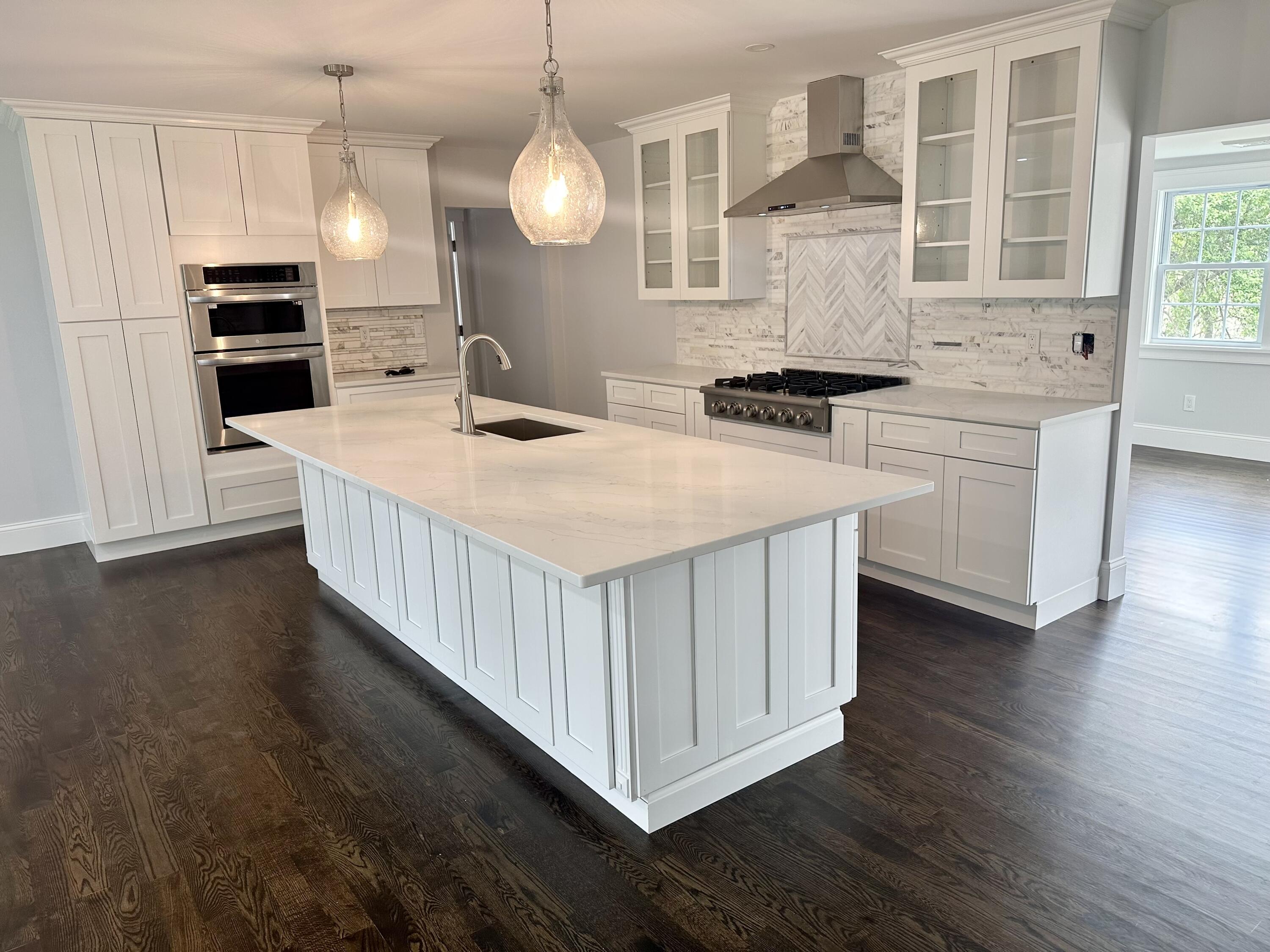 a kitchen with stainless steel appliances granite countertop a sink a stove and a wooden floors