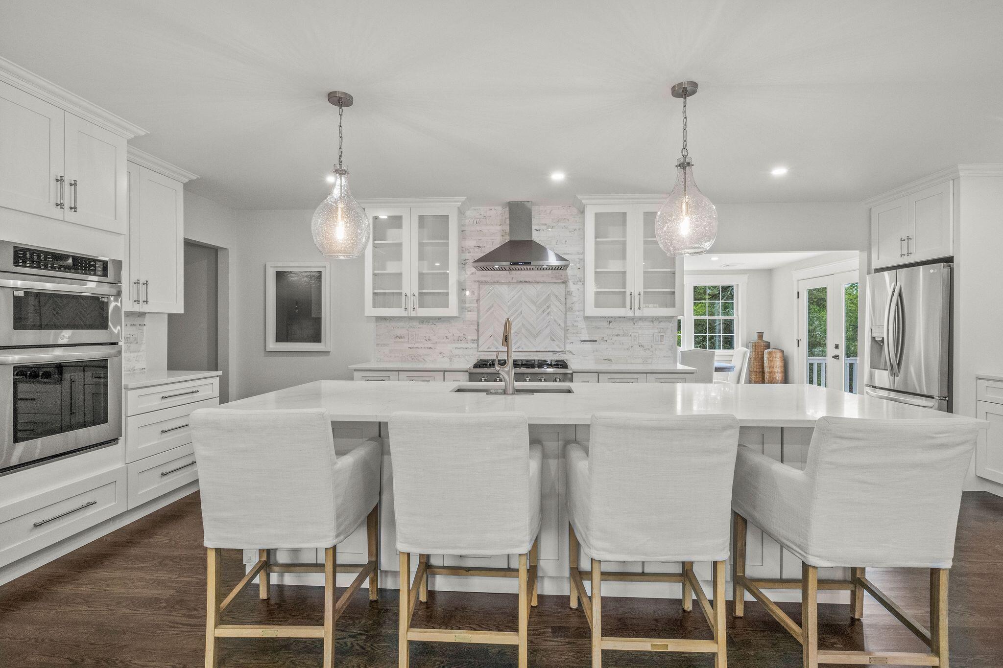 5 Locust Grove Road Harwich, MA 02645 - Photo 18 of 39 a kitchen with stainless steel appliances kitchen island granite countertop a dining table chairs and white cabinets