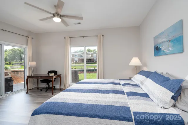 a bedroom with a bed a table and chair with a large window