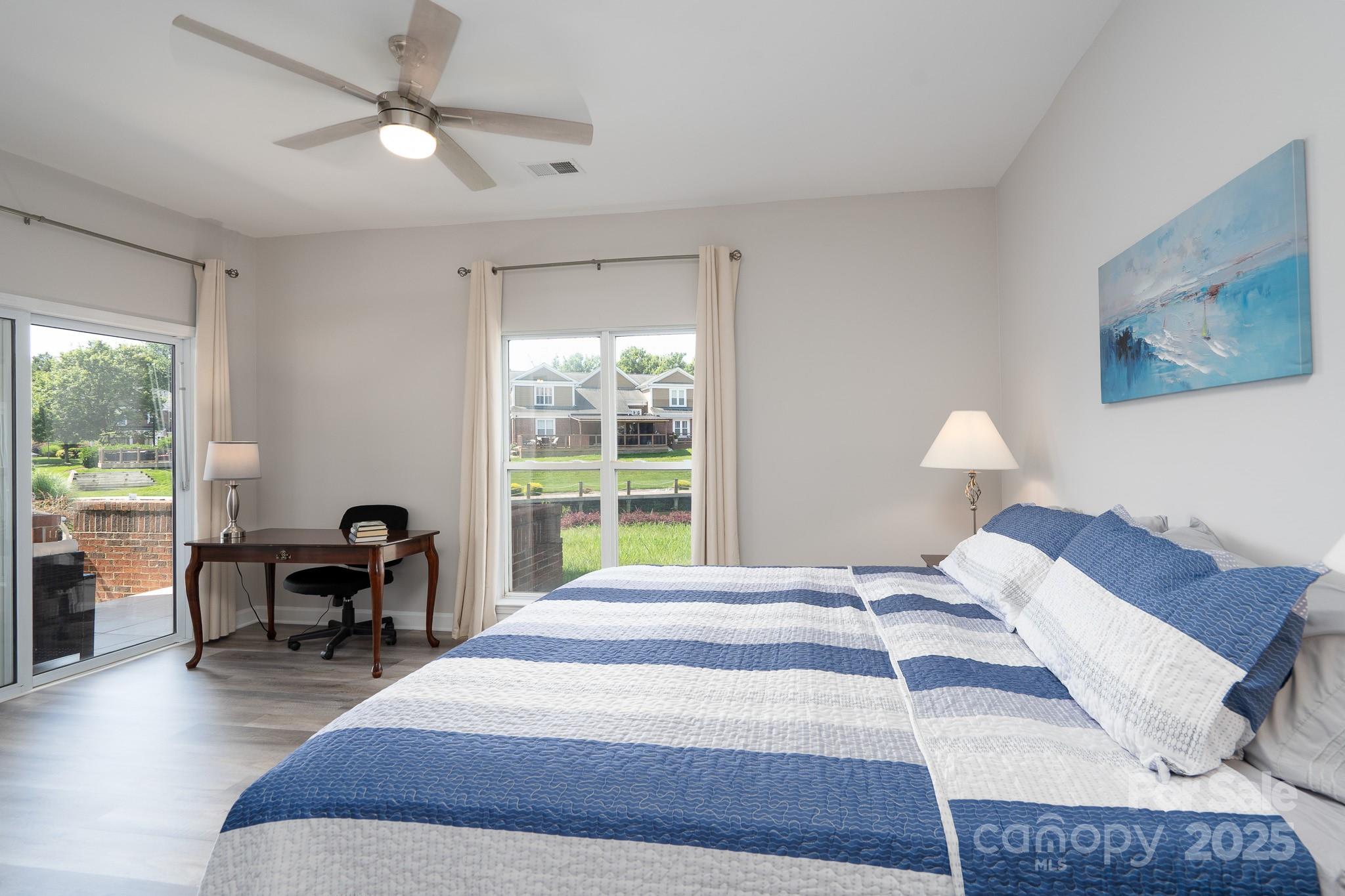 18511 Harborside Drive Cornelius, NC 28031 - Photo 14 of 27 a bedroom with a bed a table and chair with a large window