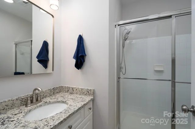 a bathroom with a granite countertop shower sink and vanity