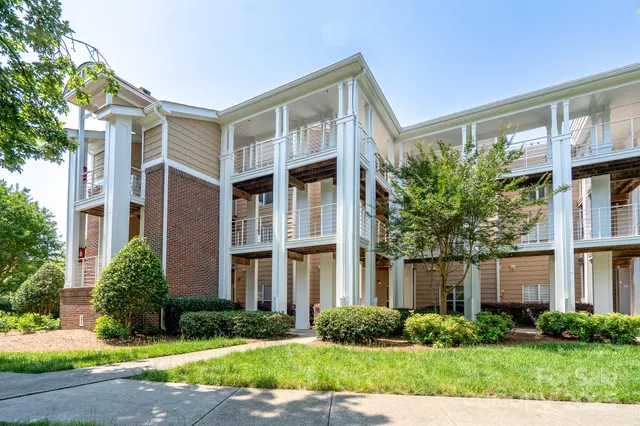 a front view of a house with garden and plants