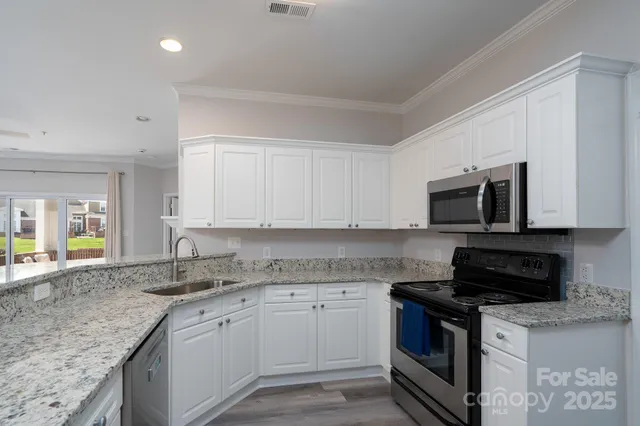 a kitchen with stainless steel appliances granite countertop a sink stove and microwave