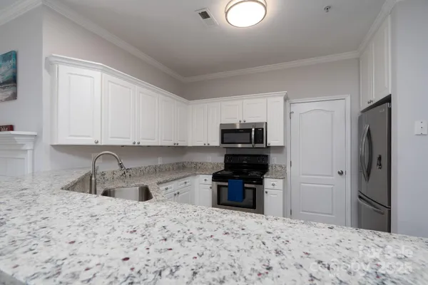 a kitchen with stainless steel appliances granite countertop a sink stove and refrigerator