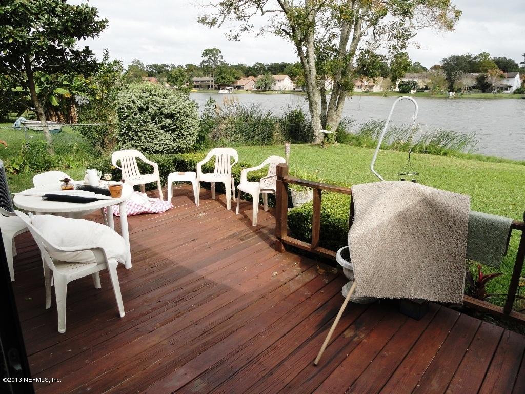 1643 Derringer Road Jacksonville, FL 32225 - Photo 20 of 21 a view of a patio with table and chairs with wooden floor and fence