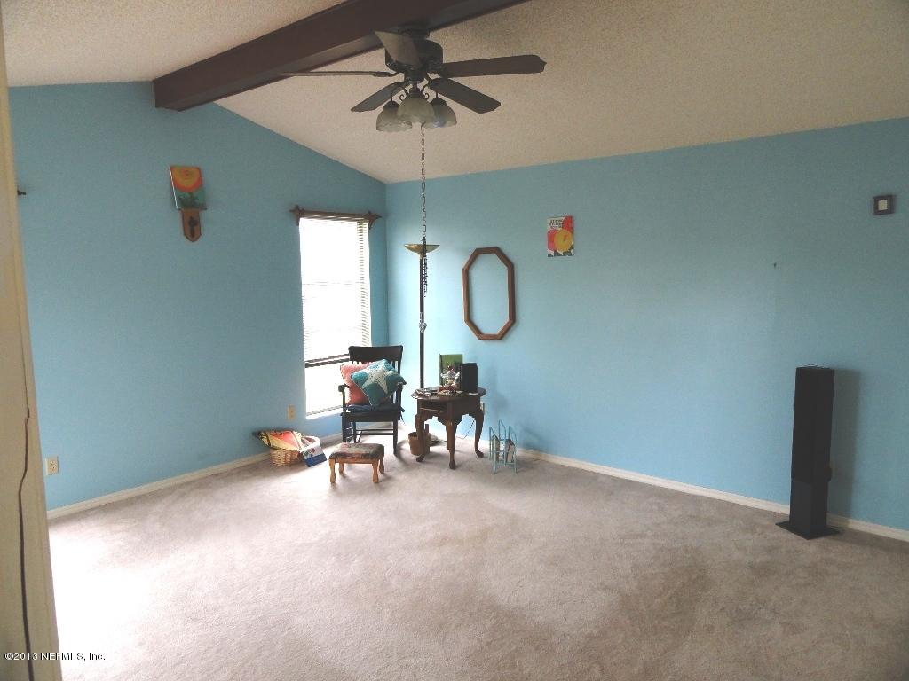 1643 Derringer Road Jacksonville, FL 32225 - Photo 9 of 21 a view of a room with a hanging light and a fan