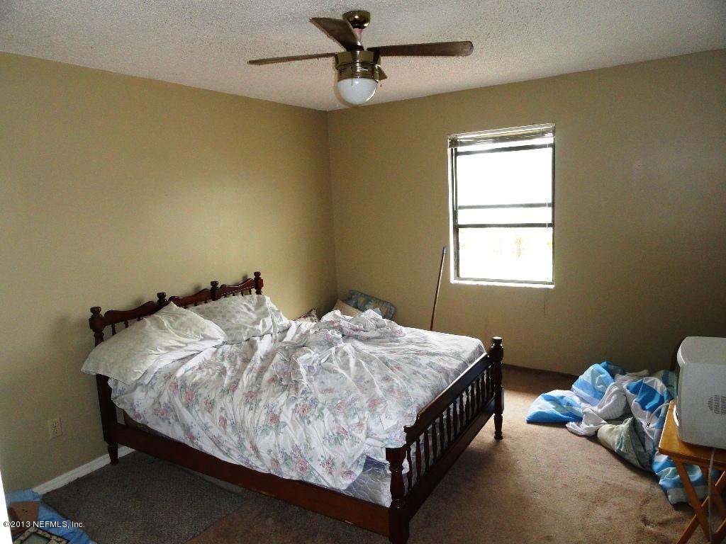 1643 Derringer Road Jacksonville, FL 32225 - Photo 10 of 21 a bed sitting in a bedroom next to a window