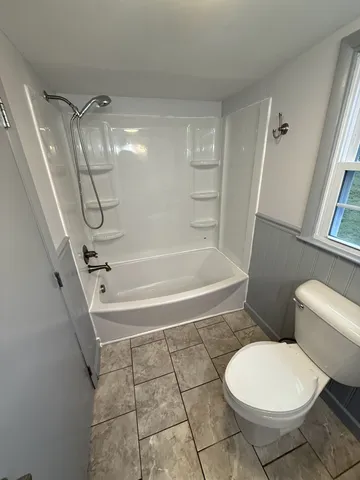 a bathroom with a toilet and a shower