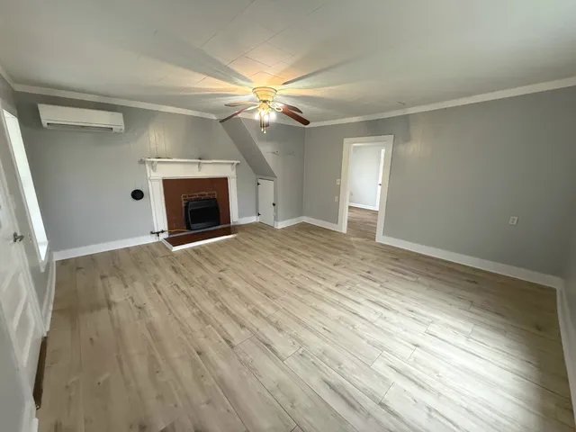 a view of empty room with fan and fireplace