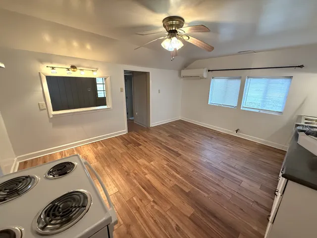 a view of a livingroom with a fireplace a chandelier and wooden floor