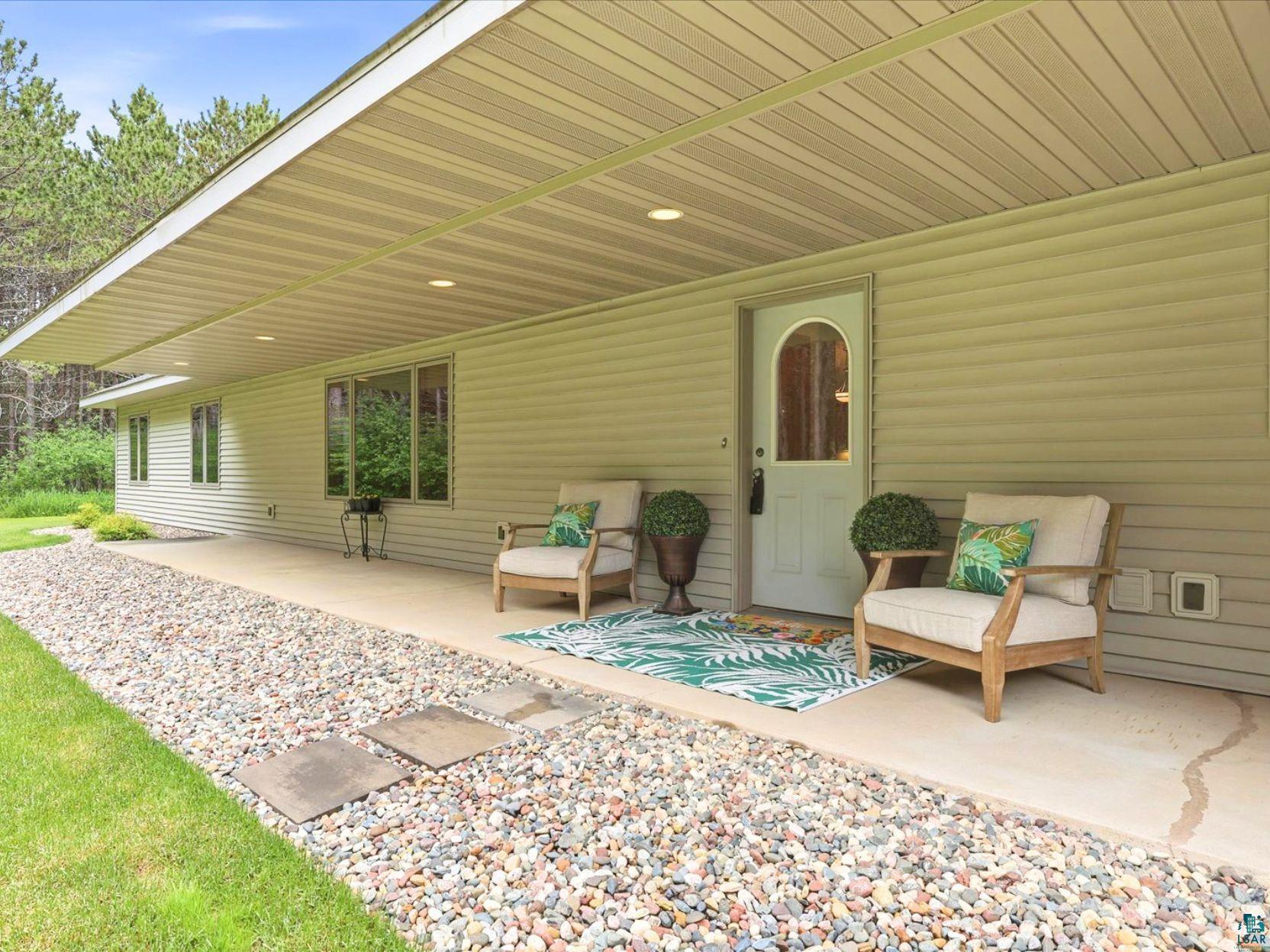 41 East Stark Road Esko, MN 55733 - Photo 2 of 19 Covered concrete patio entrance featuring recessed lighting, a light-colored entry door with an arched window, and horizontal siding