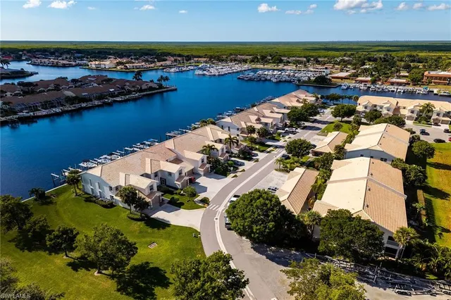 an aerial view of ocean and residential houses with outdoor space