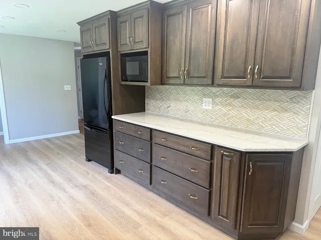 a view of a kitchen with wooden floor and electronic appliances