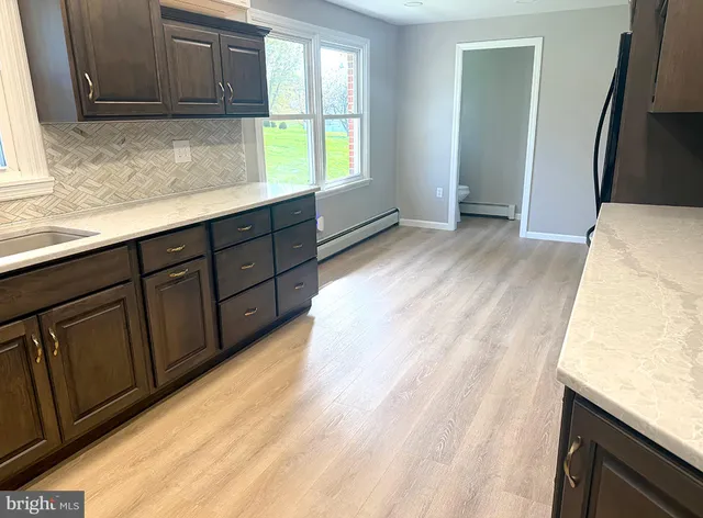 a kitchen with stainless steel appliances kitchen island granite countertop a refrigerator and a sink