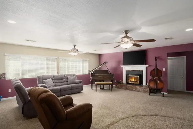 a living room with furniture a fireplace and a chandelier