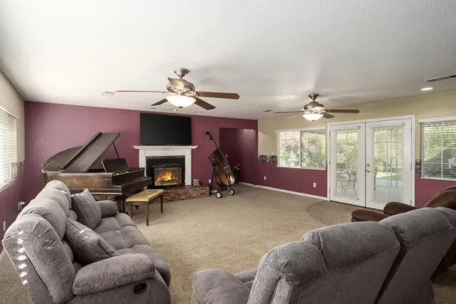 a living room with furniture a fireplace and a chandelier