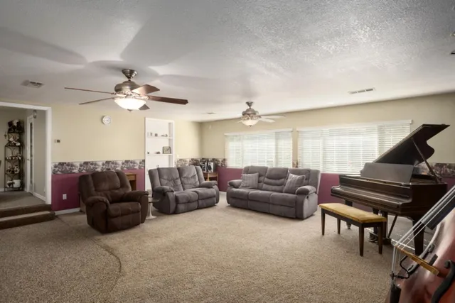a living room with furniture and a piano