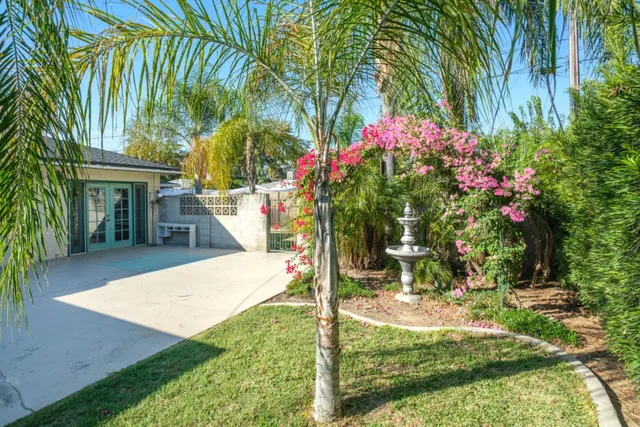 a view of a house with a yard and potted plants