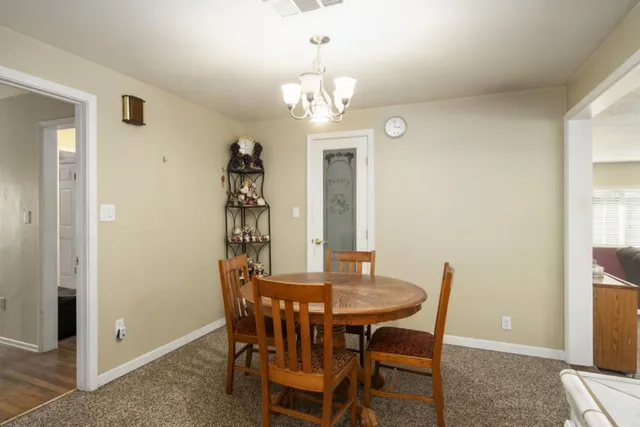 a view of a dining room with furniture and chandelier