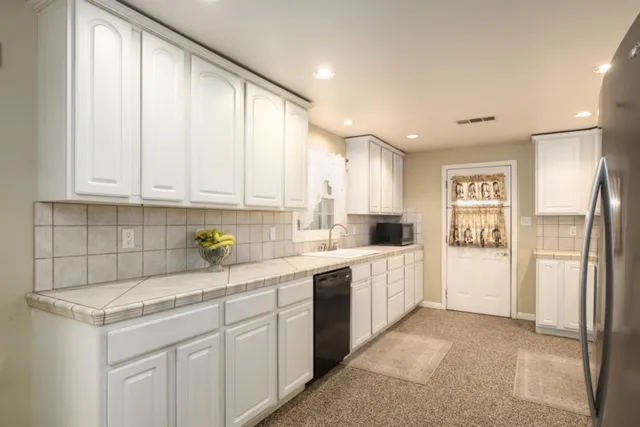 a kitchen with a refrigerator sink and cabinets