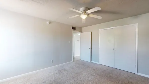 a view of an empty room with a chandelier fan