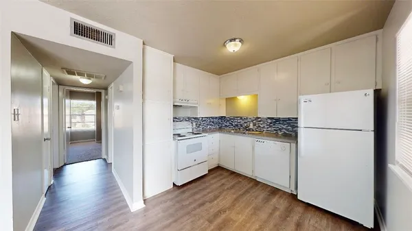 a kitchen with white cabinets and white appliances
