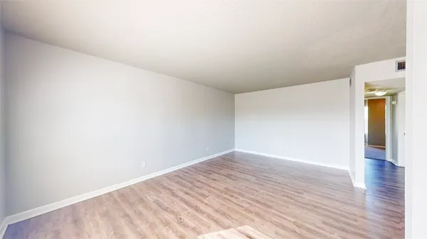 a view of an empty room with wooden floor