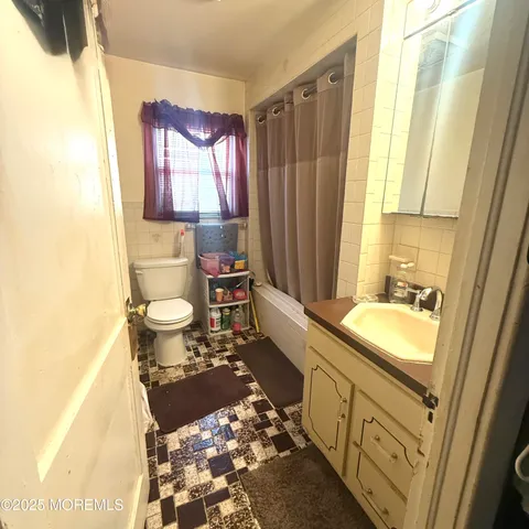 a bathroom with a sink toilet a mirror and bathtub