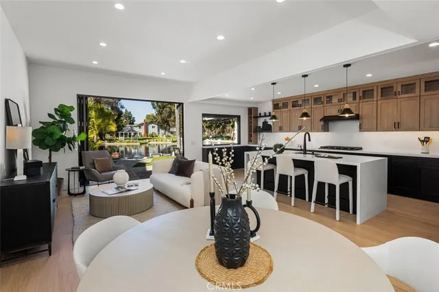 a living room with furniture kitchen view and a large window