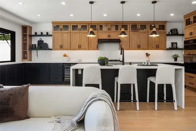 a kitchen with stainless steel appliances kitchen island granite countertop a table chairs in it and wooden floors