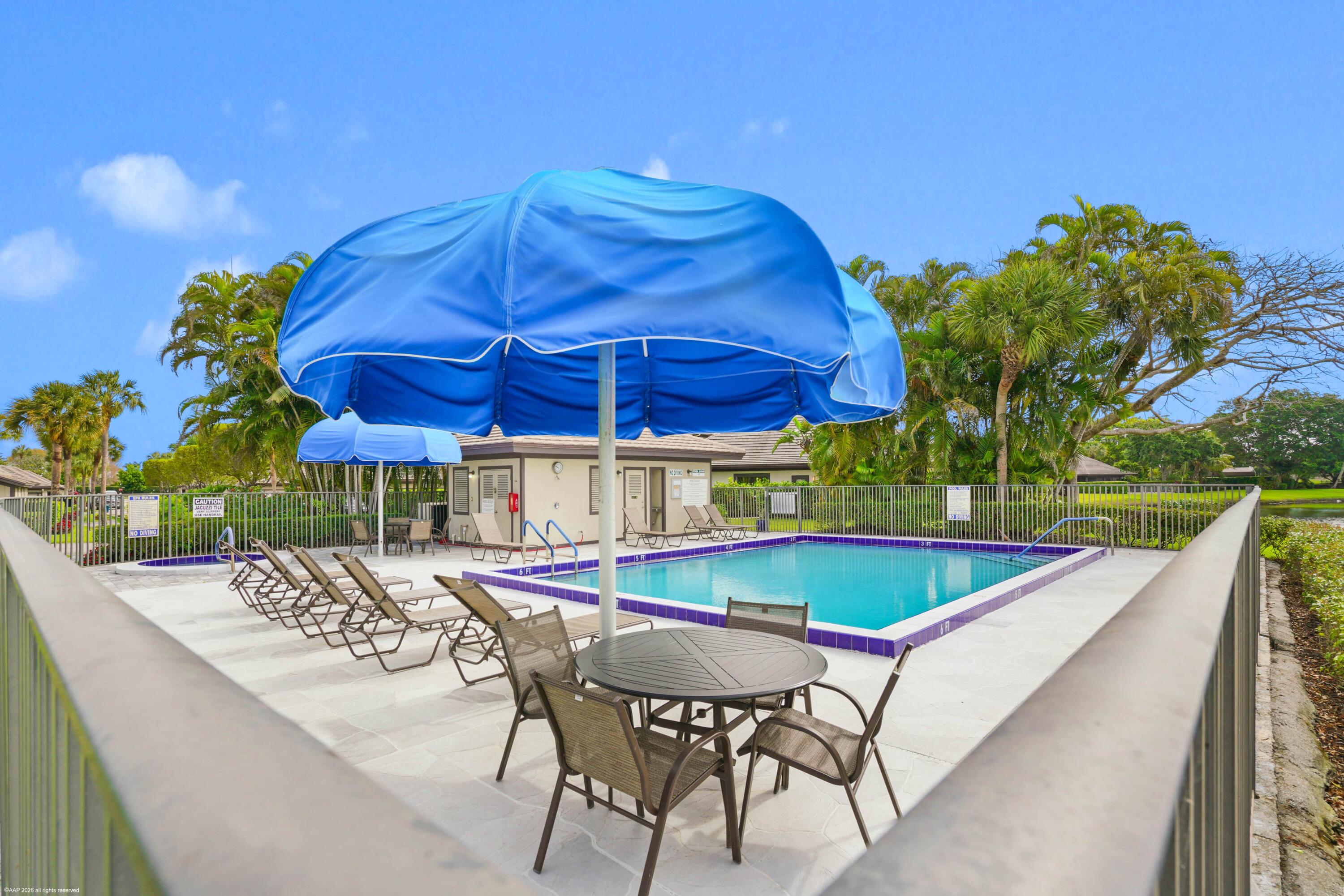 13254 Polo Club Road, Unit C101 Wellington, FL 33414 - Photo 55 of 71 a view of a patio with a table and chairs under an umbrella