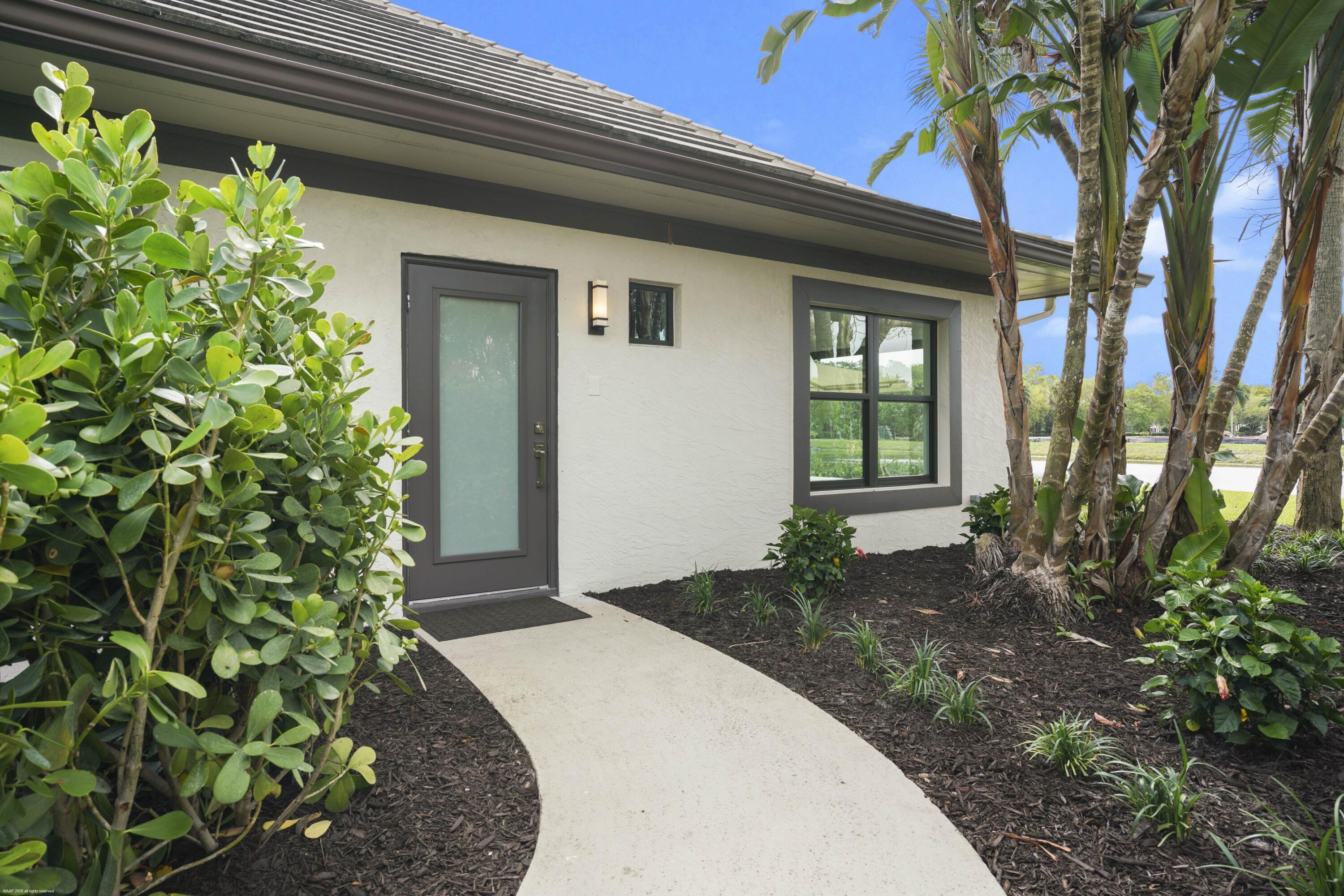 13254 Polo Club Road, Unit C101 Wellington, FL 33414 - Photo 8 of 71 a front view of a house with a garden