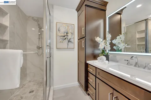 a bathroom with a granite countertop sink and a mirror