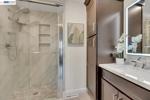 a bathroom with a granite countertop shower sink and mirror