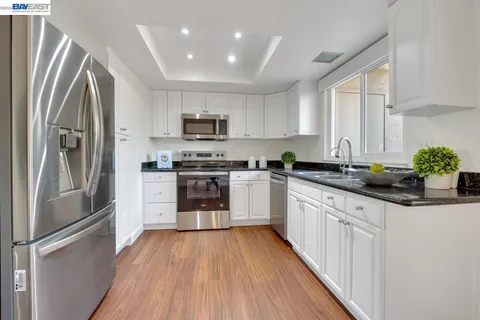 a kitchen with stainless steel appliances a refrigerator sink and microwave