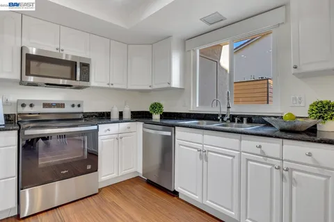 a kitchen with white cabinets stainless steel appliances and sink