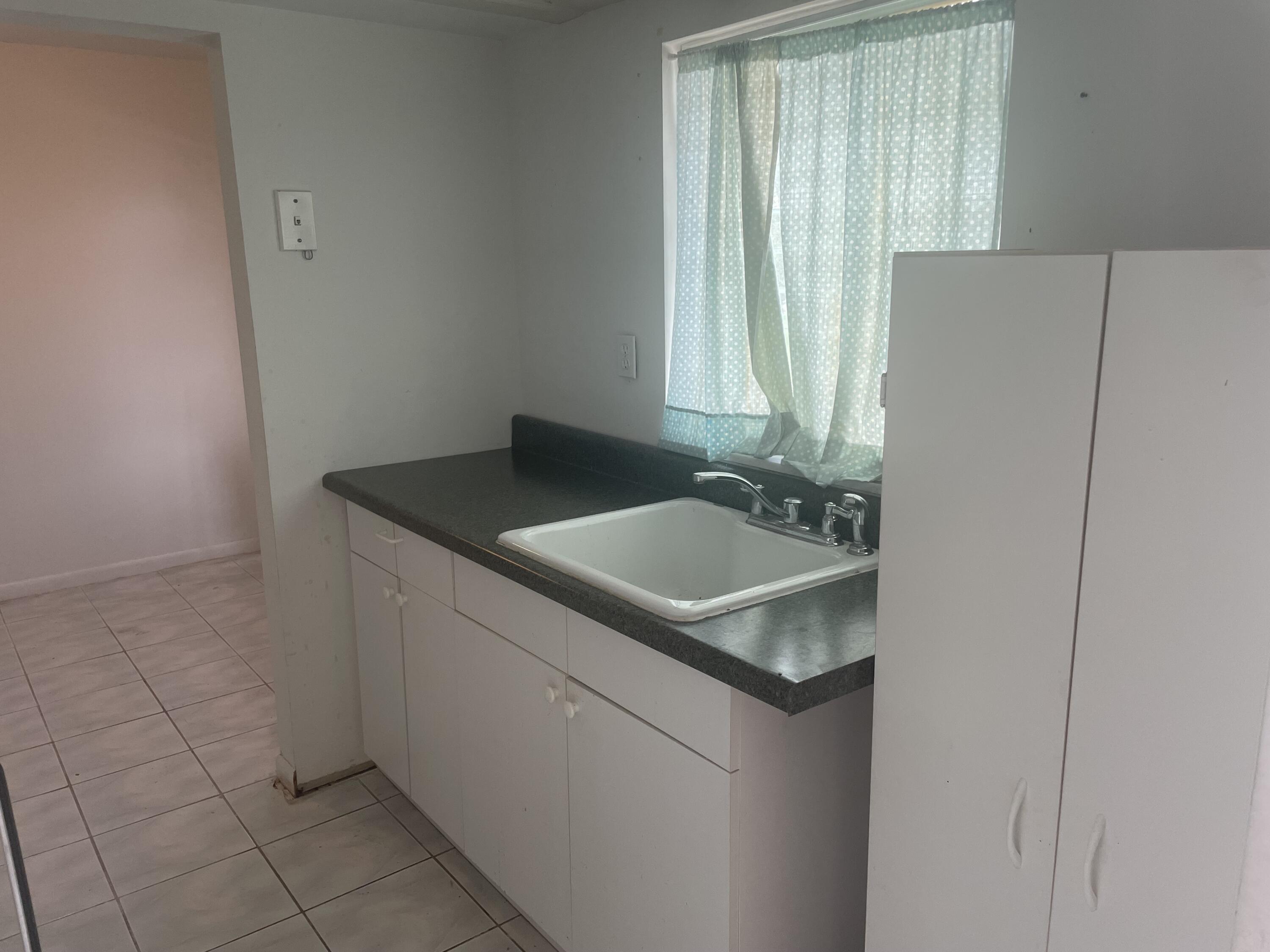 20 Golfs Edge, Unit E West Palm Beach, FL 33417 - Photo 1 of 7 a sink sitting next to a bathroom and mirror